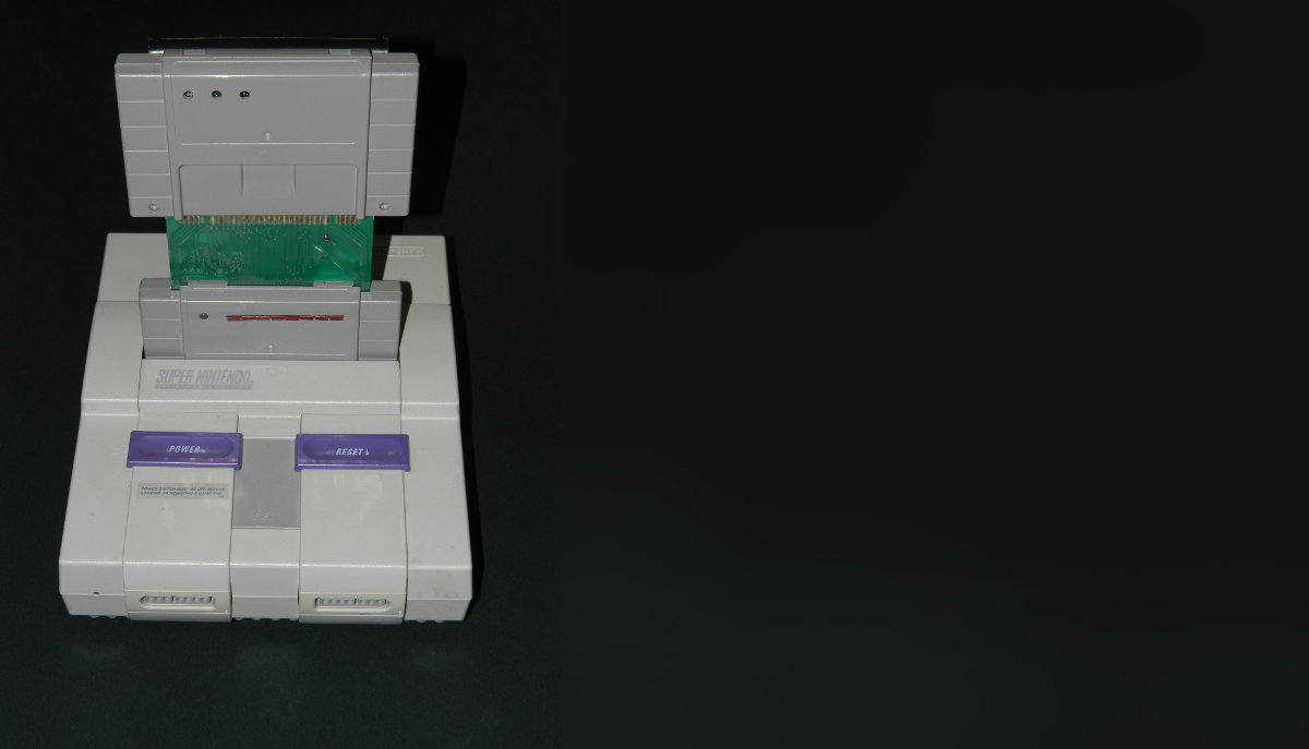 Super Nintendo Entertainment System (SNES) with cross-platform software development interface including ROM (read-only memory) emulation cartridge with battery backup